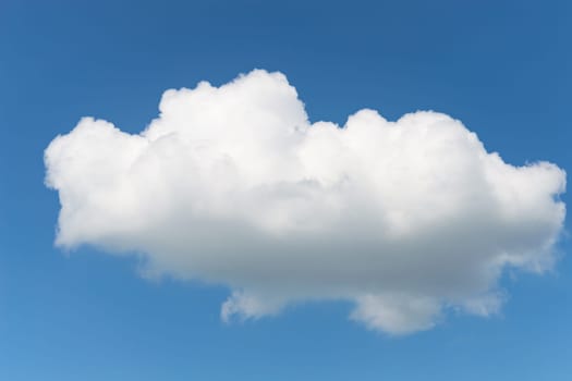 One single fluffy Cumulus cloud in clear deep blue summer sky