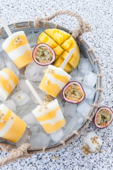 Homemade popsicles with passion fruit and mango