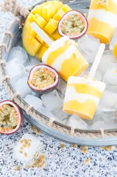 Homemade popsicles with passion fruit and mango