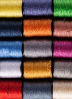 Colorful cotton reels lined up in a row and viewed from above