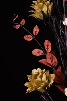 Flower arrangement with warm dark tones on a black background