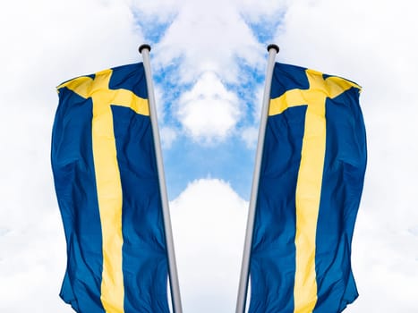 Swedish national flag arranged in front of a blue sky.