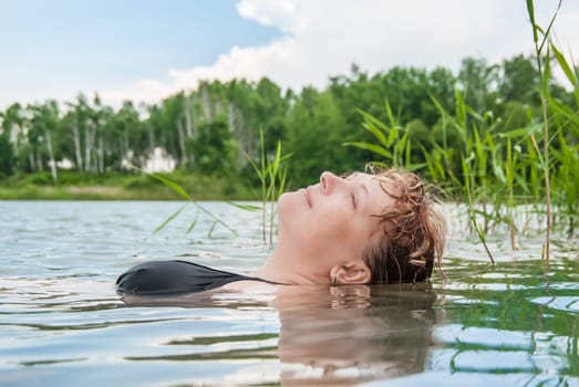 The woman blindly swims in the lake