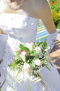 Beautiful white wedding bouquet in hands of the bride..