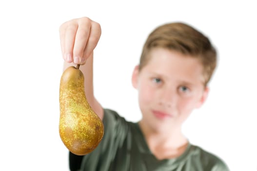 Frontal head and shoulder view of a young male teenager against a white background with his right hand holding a pear in front of him