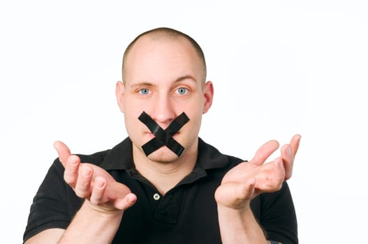 Head portrait of a young man with his mouth glued over a cross against a white background and hands raised perplexed gesticulating