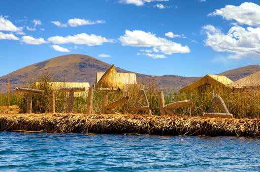 Manmade floating island with a sign spelling out Titikaka on Lake Titicaca in Peru