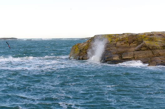 blowing on the swedish west coast and the waves splash on the rock