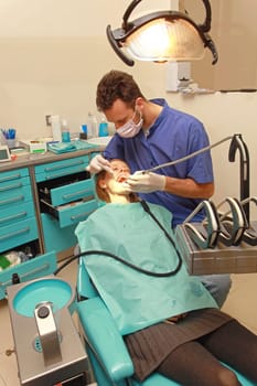 Dentist Drilling Tooth of Young Woman