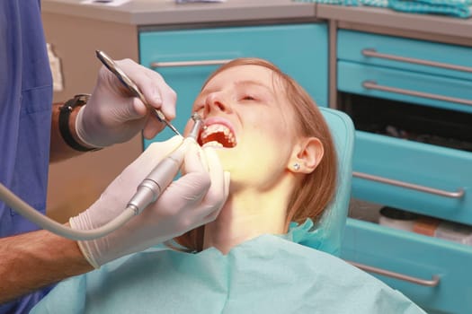 Dentist Polishing and Cleaning Teeth of Young Lady