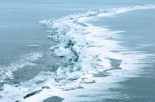 Winter scene at a frozen lake with ice-pack and other ice formations