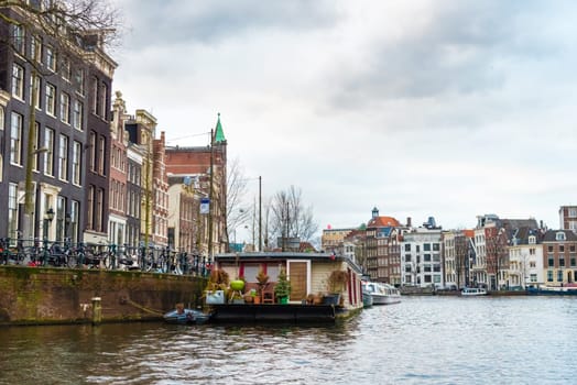 Amsterdam, Netherlands - January 9, 2017: Street view with traditional Dutch row houses and famous canals in Amsterdam historical city center, the Netherlands’ capital, known for its artistic heritage