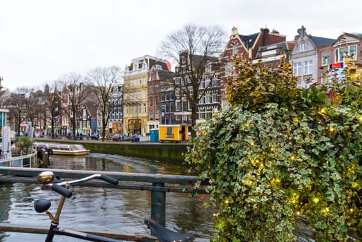 Amsterdam, Netherlands - January 9, 2017: Street view with traditional Dutch row houses and famous canals in Amsterdam historical city center, the Netherlands’ capital, known for its artistic heritage