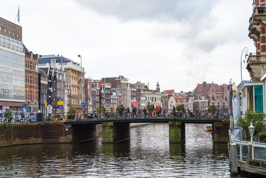 Amsterdam, Netherlands - January 9, 2017: Street view with traditional Dutch row houses and famous canals in Amsterdam historical city center, the Netherlands’ capital, known for its artistic heritage