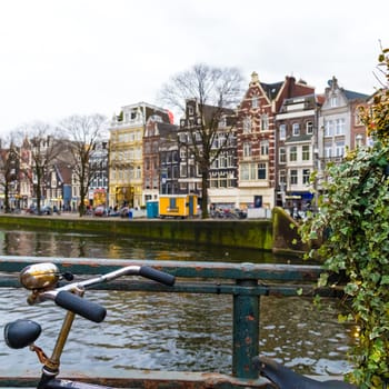 Amsterdam, Netherlands - January 9, 2017: Street view with traditional Dutch row houses and famous canals in Amsterdam historical city center, the Netherlands’ capital, known for its artistic heritage