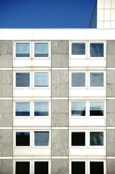 The angular exterior façade of a school building with large windows.