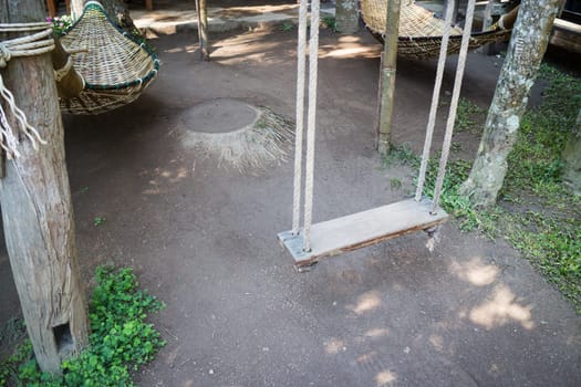 Empty wooden swing in the garden, stock photo