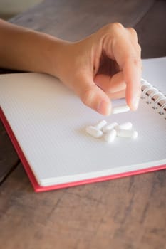 Hand on white pill medicine, stock photo