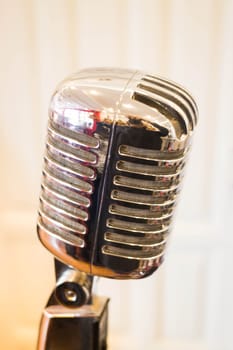 Vintage retro style microphone in white room, stock photo