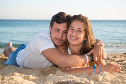 Happy teenage couple posing in the beach