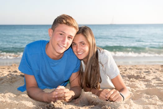Happy teenage couple posing in the beach