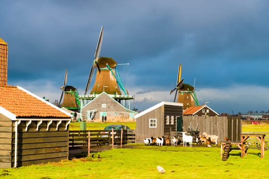 Zaanse Schans, Netherlands - January 10, 2017: Rural Dutch scenery with water canals in Zaanse Schans village known for well-preserved historic windmills and row houses near Amsterdam, Netherlands.