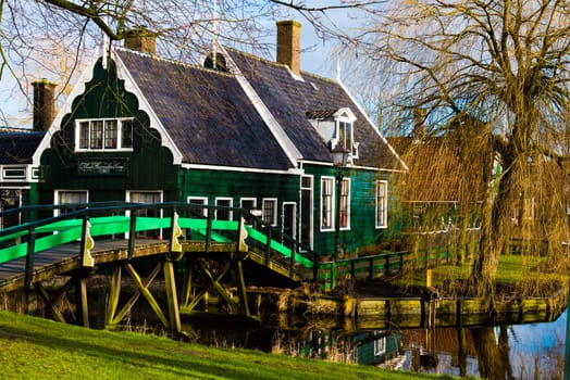 Zaanse Schans, Netherlands - January 10, 2017: Rural Dutch scenery with water canals in Zaanse Schans village known for well-preserved historic windmills and row houses near Amsterdam, Netherlands.