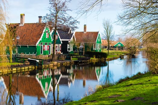 Zaanse Schans, Netherlands - January 10, 2017: Rural Dutch scenery with water canals in Zaanse Schans village known for well-preserved historic windmills and row houses near Amsterdam, Netherlands.