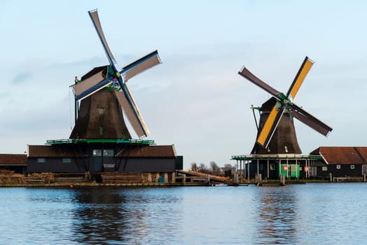 Zaanse Schans, Netherlands - January 10, 2017: Rural Dutch scenery with water canals in Zaanse Schans village known for well-preserved historic windmills and row houses near Amsterdam, Netherlands.