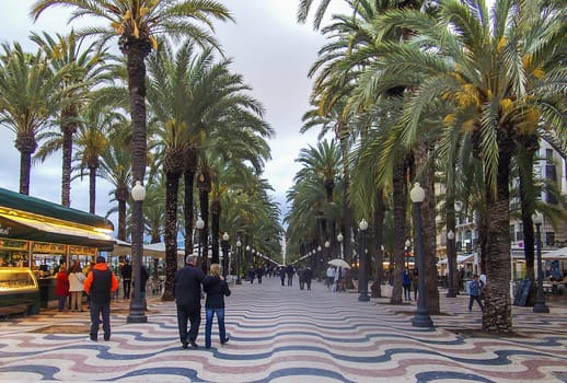 Alicante, Spain, may 2013: Wiggly patterns of Explanada with people walking under the palms