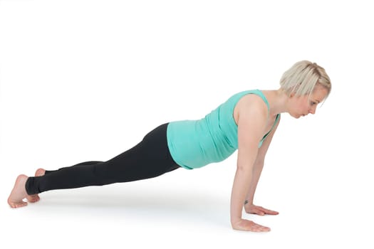 Full body view of a young blonde woman during yoga exercise "Cobra"" Step1 against a white background with a slight shadow."