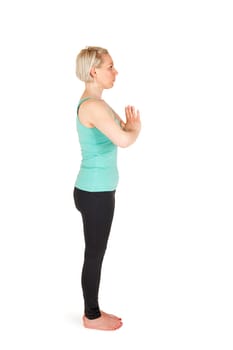 Full-body view of a young blonde woman during yoga exercise "Standing Prevention"" Step 1 against a white background with a slight shadow"