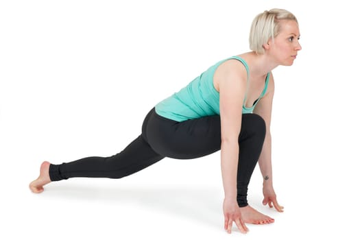 Full-body view of a young blonde woman doing yoga exercises against a white background with a slight shadow