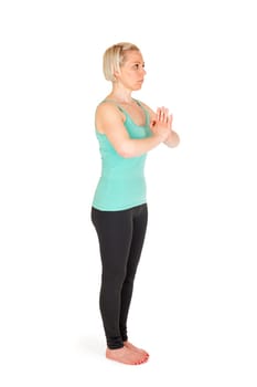 Full-body view of a young blonde woman during yoga exercise "Standing Prevention"" Step 1 against a white background with a slight shadow"