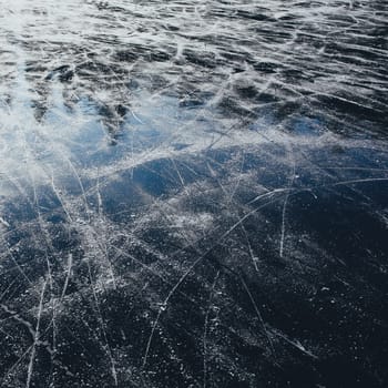 Surface of outdoor ice with snow, replete with skate marks. Abstract Ice background with focus on foreground