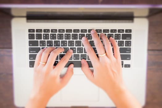 Typing on keyboard laptop top view of wooden table, stock photo