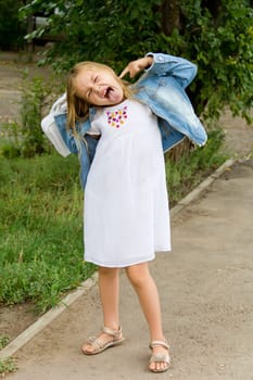 Cute girl makes faces and put out tongue
