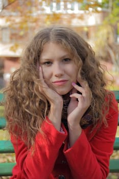 Portrait of thinking young woman in red coat