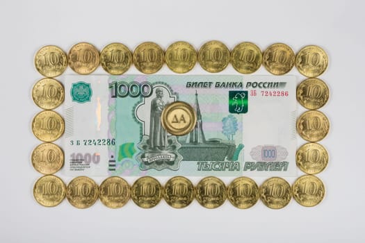 Russian thousandth banknote lined the perimeter of a ten coins in the middle of the coin is a "Yes"" sign"