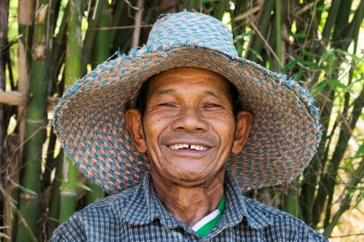Portrait of an old Asian man with a straw hat
