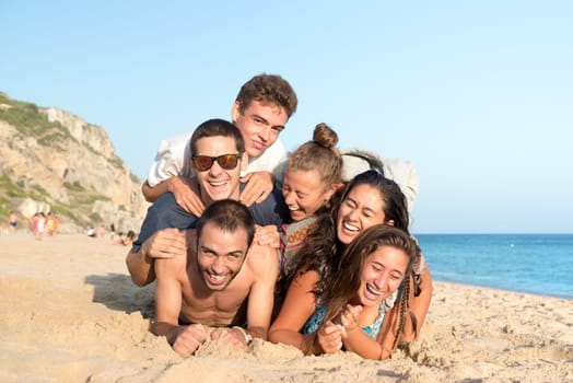 Group of happy teenage friends having fun at the beach