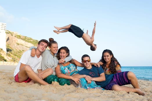 Group of happy teenage friends having fun at the beach