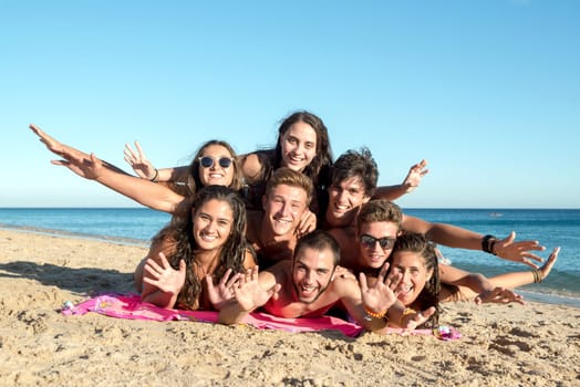 Group of happy teenage friends having fun at the beach