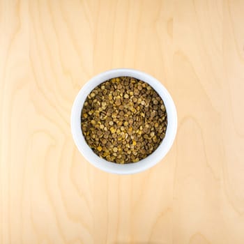 Heart shaped from raw dry brown lentils in cup, top view, square composition, food preparation, copy space, healthy lifestyle, eating legumes