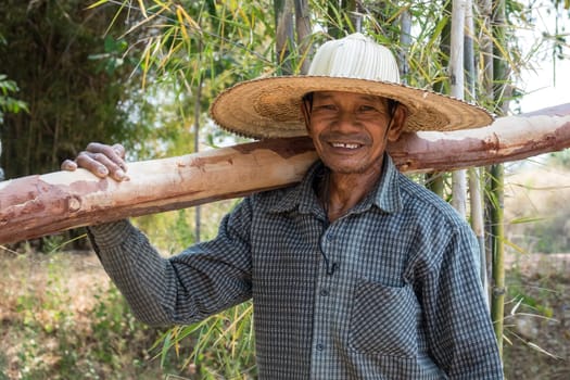 Portrait of an old Asian man with a straw hat