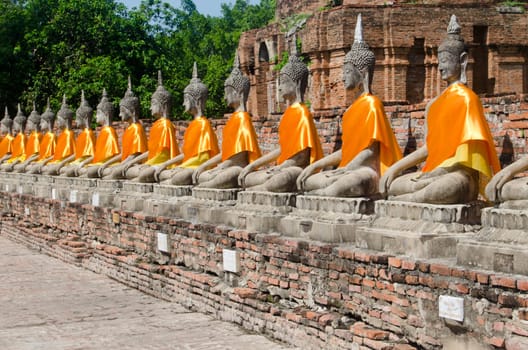 Row of stone Buddhas in seated meditation pose