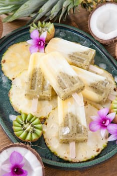 Homemade popsicles with pineapple,coconut and kiwi