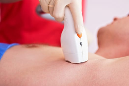 man receiving laser epilation at armpit on beauty center