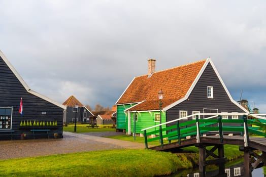 Zaanse Schans, Netherlands - January 10, 2017: Rural Dutch scenery with water canals in Zaanse Schans village known for well-preserved historic windmills and row houses near Amsterdam, Netherlands.