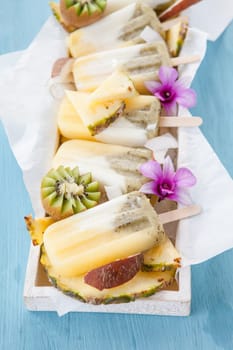 Homemade popsicles with pineapple,coconut and kiwi